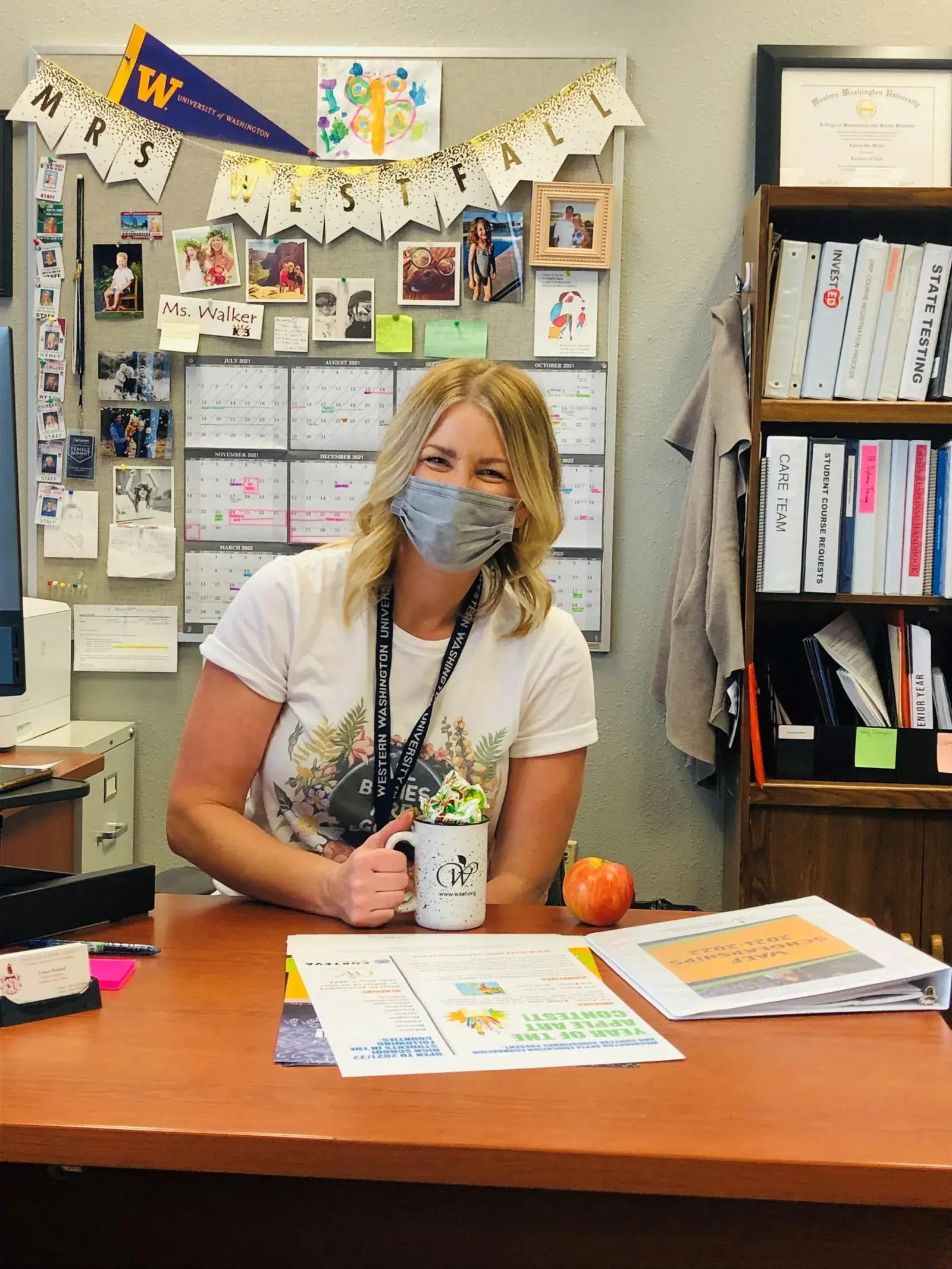 A woman at her desk in an office decorated with bunting and photographs